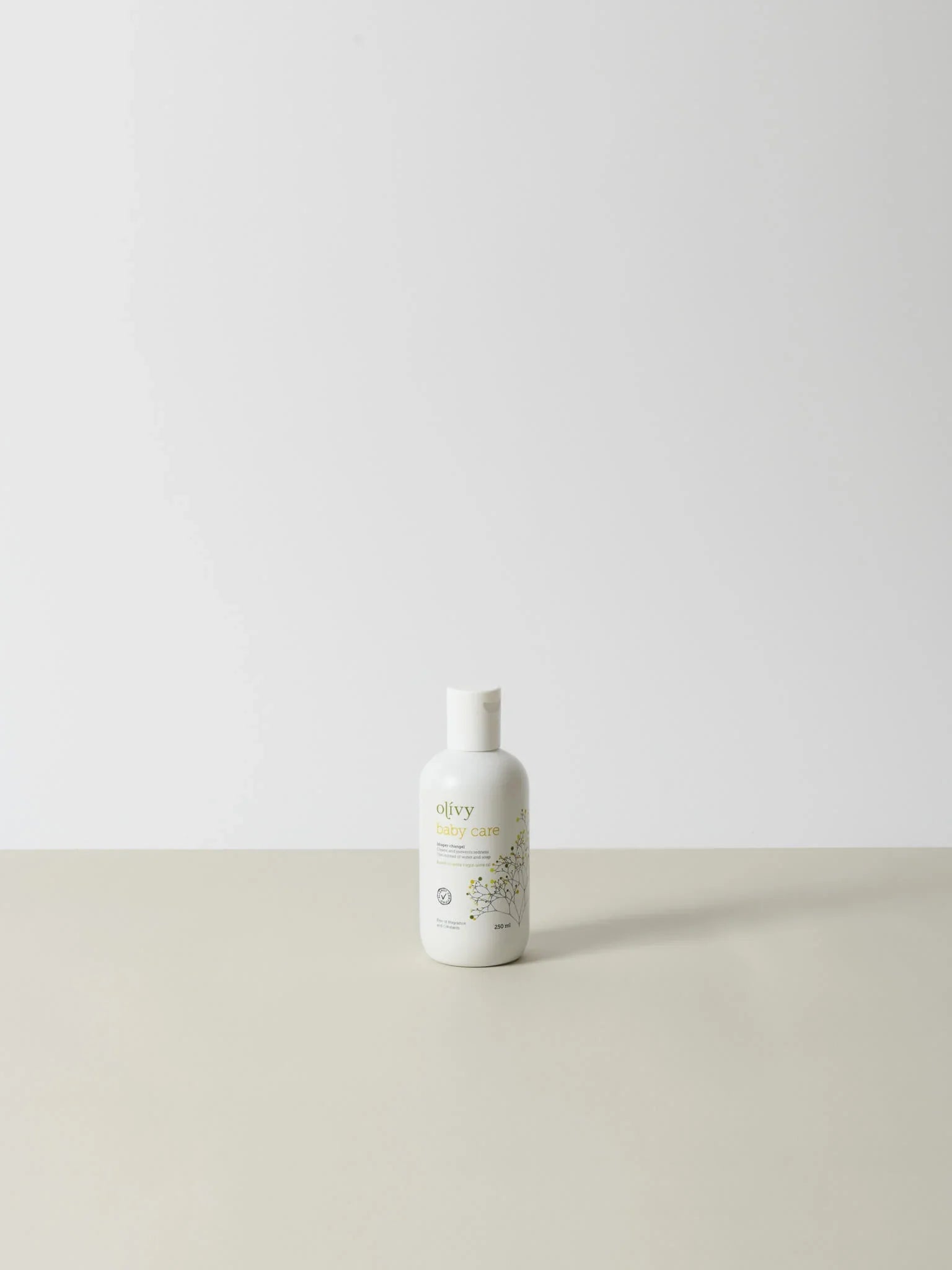 Hvid flaske med minimalistisk label i bløde farver, naturlig og nænsomt designet premium olie på 100 ml.