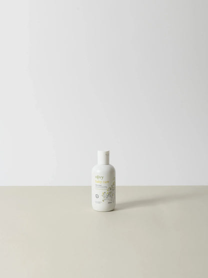 Hvid flaske med enkel etiket i beige og grøn med teksten Olivy 100 ml, naturlig og premium kvalitet, stående på lys. - Olivy (100ml)