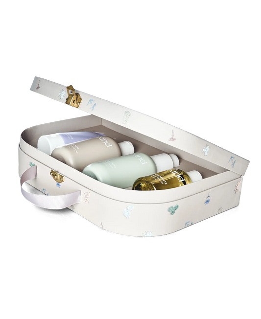 Åben pastelrosa kosmetikæske med fine prikker og guldhåndtag, indeholder fire premium hudplejeprodukter i naturlige, milde. - SoKind Dear Baby Skin Care Kit